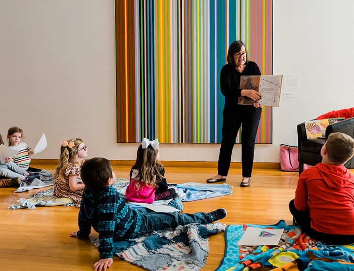 Volunteer reading to children in art galleries
