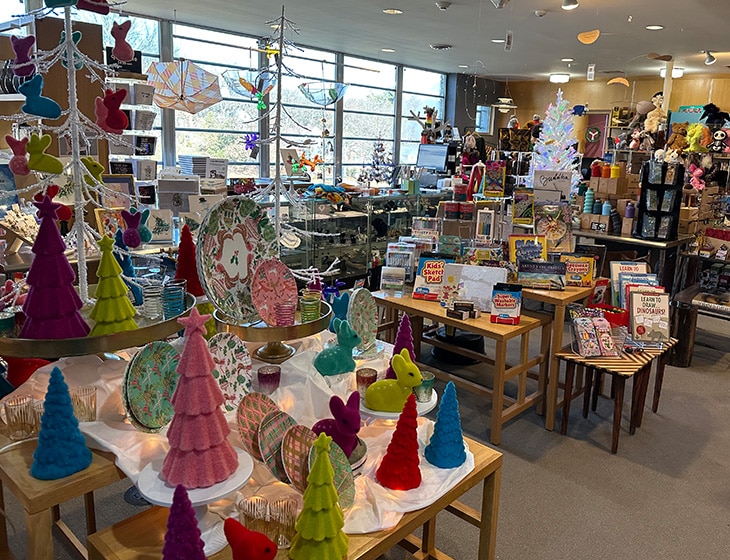 The Museum Shop at the Art Center. The front table is filled with brightly colored holiday home decor.