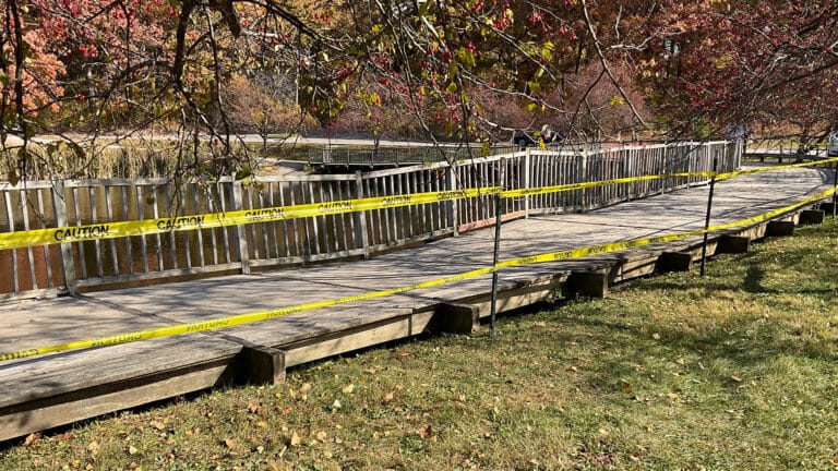 Outside "Greenwood Pond: Double Site" art installation bridge with caution tape around it.