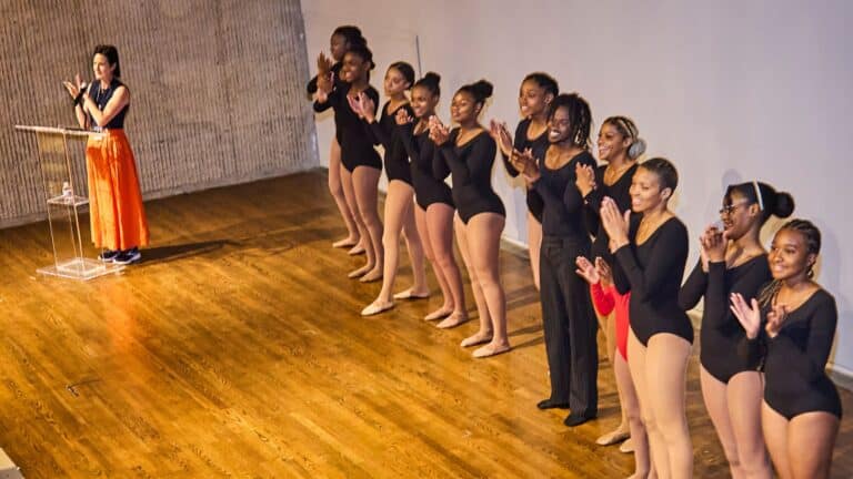 Ballet performers standing on stage.