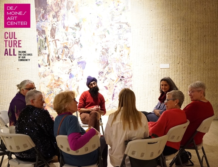 CultureALL’s Open Book program; small group of people sitting in chairs in the Art Center's gallery. They're sitting, looking at, and discussing a work of art that hangs on the wall.