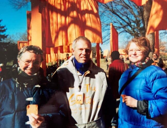 Three people standing and smiling, posing for a photo together—From left: Tom Worthen, Dale Jansen, and Amy Worthen at the Inauguration of Christo and Jeanne-Claude’s The Gates, Central Park, New York, 2005. Photo by Maria Worthen.