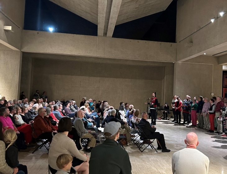 Des Moines Gay Men's Chorus preforming to a large group of people in the Des Moines Art Center's I. M. Pei building.
