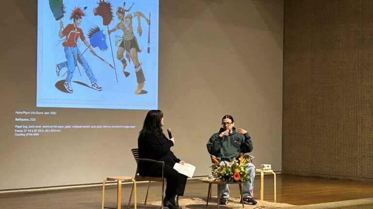Art Center Associate Curator Beth Gollnick, and 2026 Iowa Artist Henry Payer sitting on stage talking.