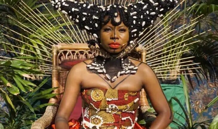 Woman sitting in a chair dressed in traditional Jamaican garments. Image: Simone Harris as Lady Blake. Photo by Kevin Tschierse.