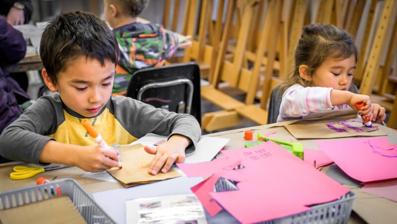 Two children working on a paper art project